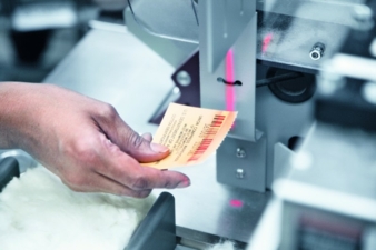 Operator scanning bale tag with the coded bale identification information to link with cotton quality parameters generated by the HVI at the cotton...